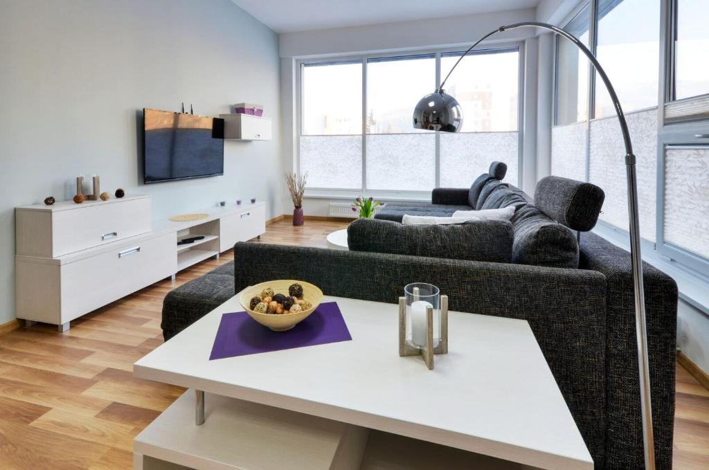 ein Wohnzimmer mit Sofa und Tisch in der Unterkunft Apartments MODOM in Liptovský Mikuláš