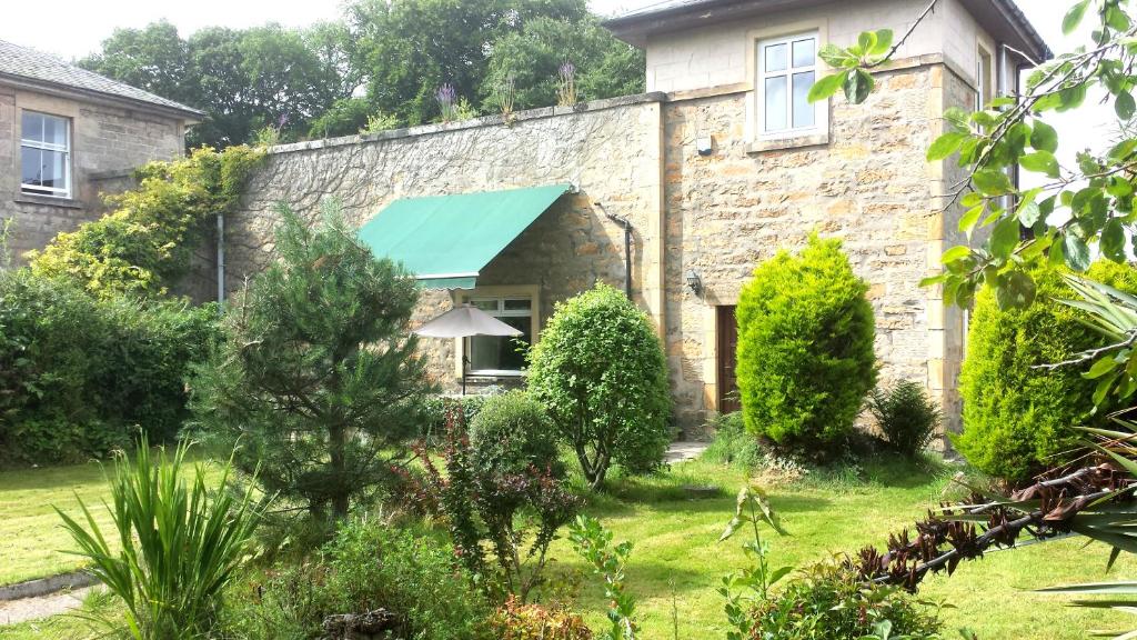 an old stone house with a green awning at Elgin Self Catering Holiday Cottage in Elgin