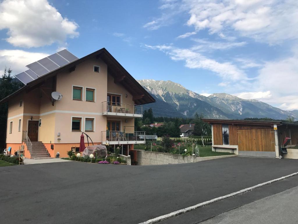 a house with a solar roof with mountains in the background at Ferienwohnung Mujcic in Hermagor