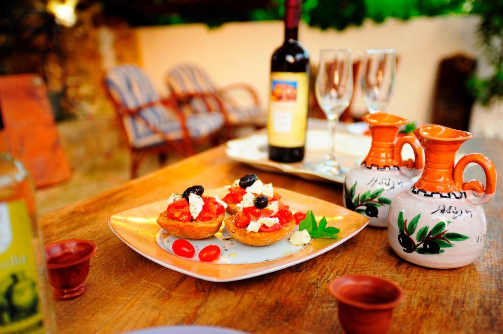 a table with a plate of food and a bottle of wine at Idili in Panormos Rethymno