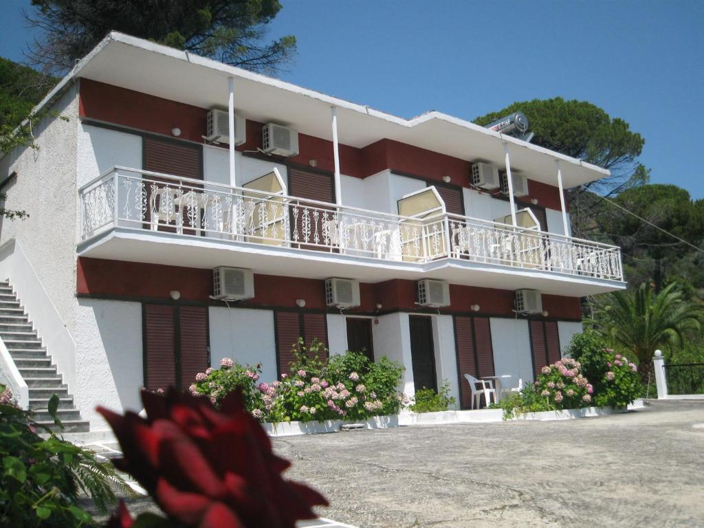 un edificio con balcones y flores delante de él en Bellina Studios, en Agia Paraskevi