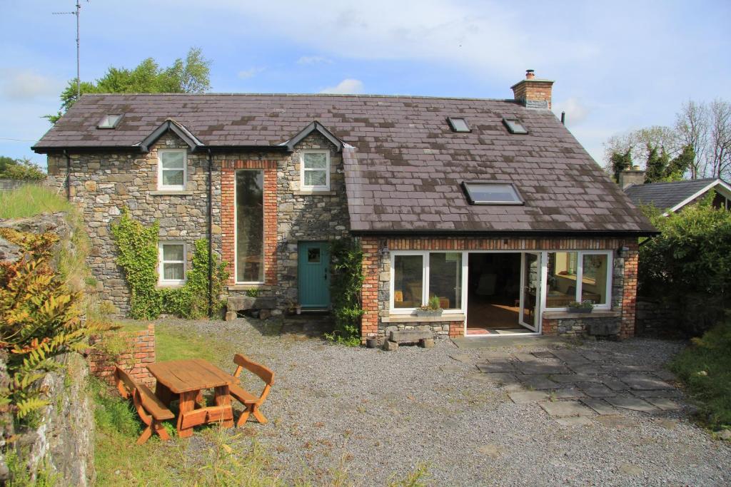 a brick house with a picnic table in front of it at Glenboy Country Accommodation in Oldcastle