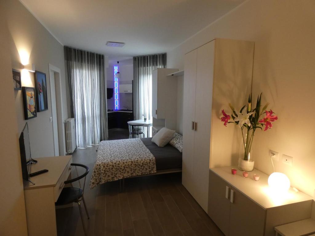 a small hotel room with a bed and a desk at Metro Apartment in Collegno