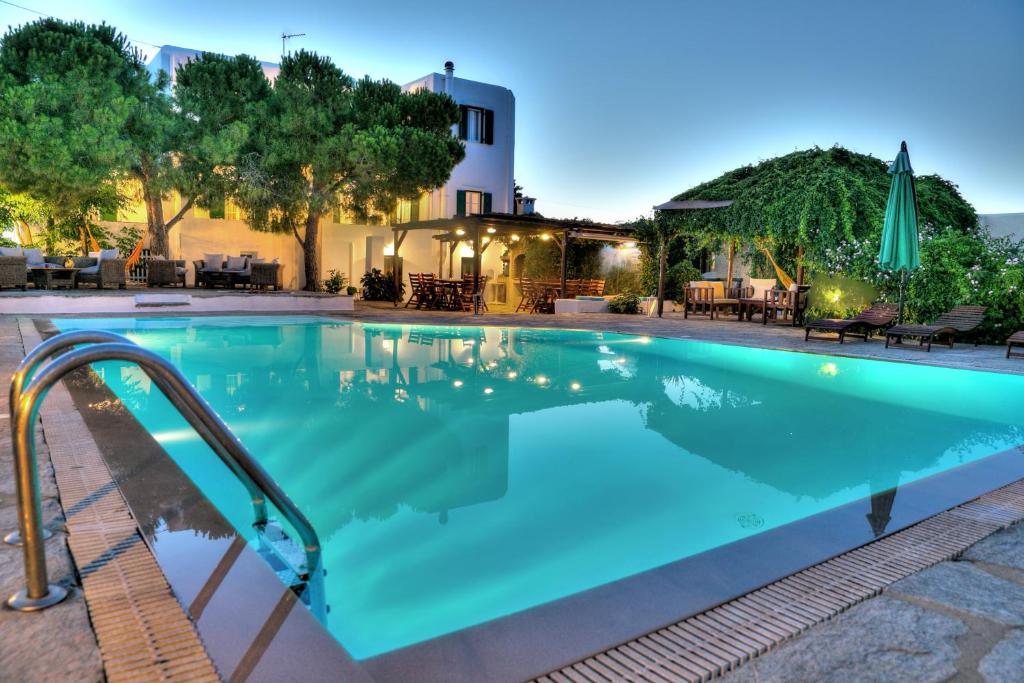 - une grande piscine d'eau bleue la nuit dans l'établissement Tzane Apartments, à Chrissi Akti