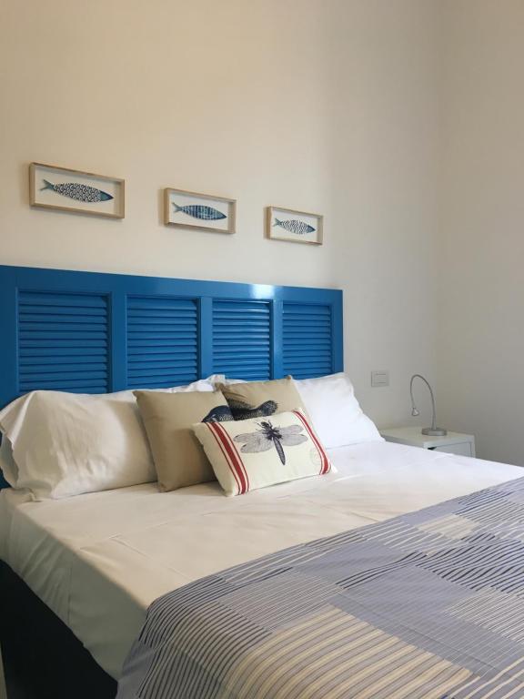 a bedroom with a large bed with a blue headboard at Casa Sole in Minori