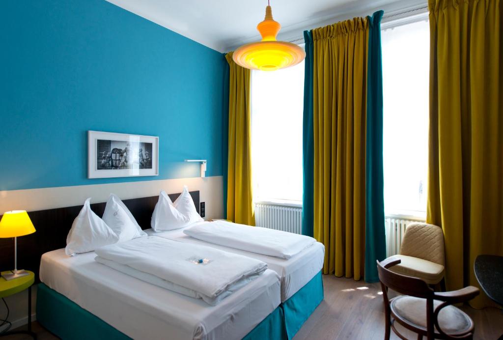 a hotel room with a large bed with blue walls at Hotel Beethoven Wien in Vienna