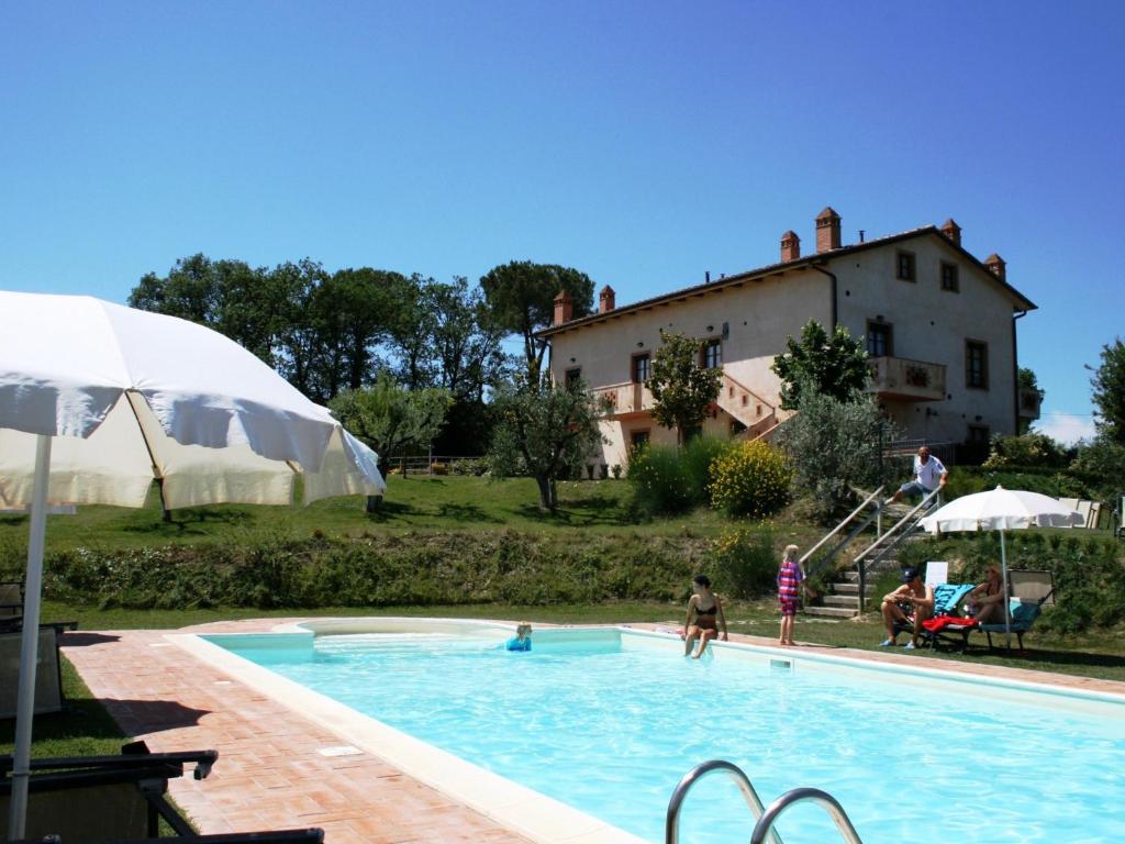 a pool with people playing in it with a house at Poggio Olivo in Acquaviva