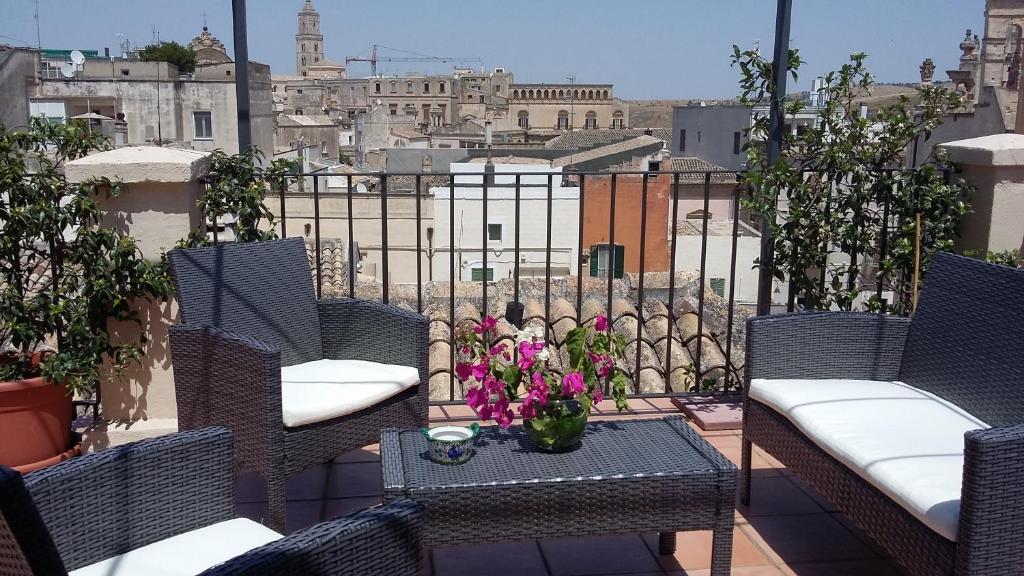 a patio with chairs and a table with flowers on it at Palazzotto Morelli in Matera