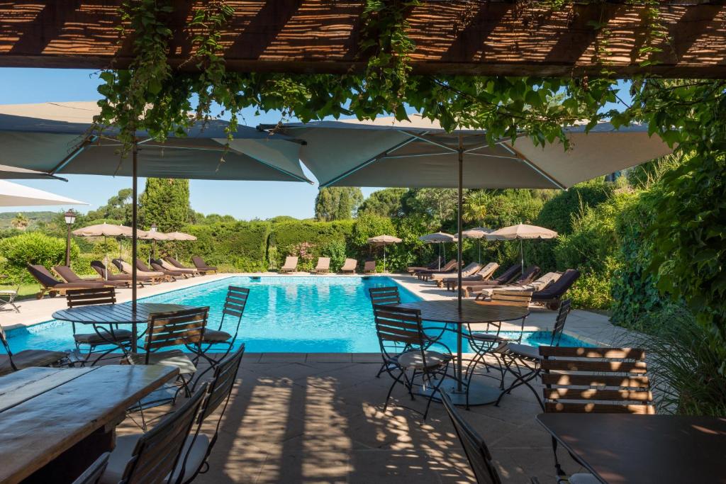 une piscine avec tables, chaises et parasols dans l'établissement Saint-Vincent, à Saint-Tropez