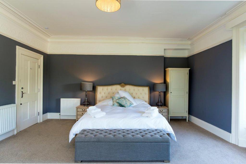 a bedroom with a large bed with blue walls at Baie Mooar House, Boutique B&B in Ramsey