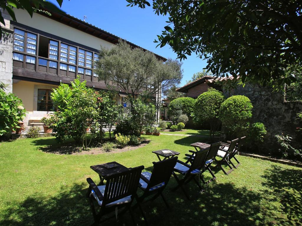 a group of chairs and a table in a yard at Hotel La Arquera in Llanes