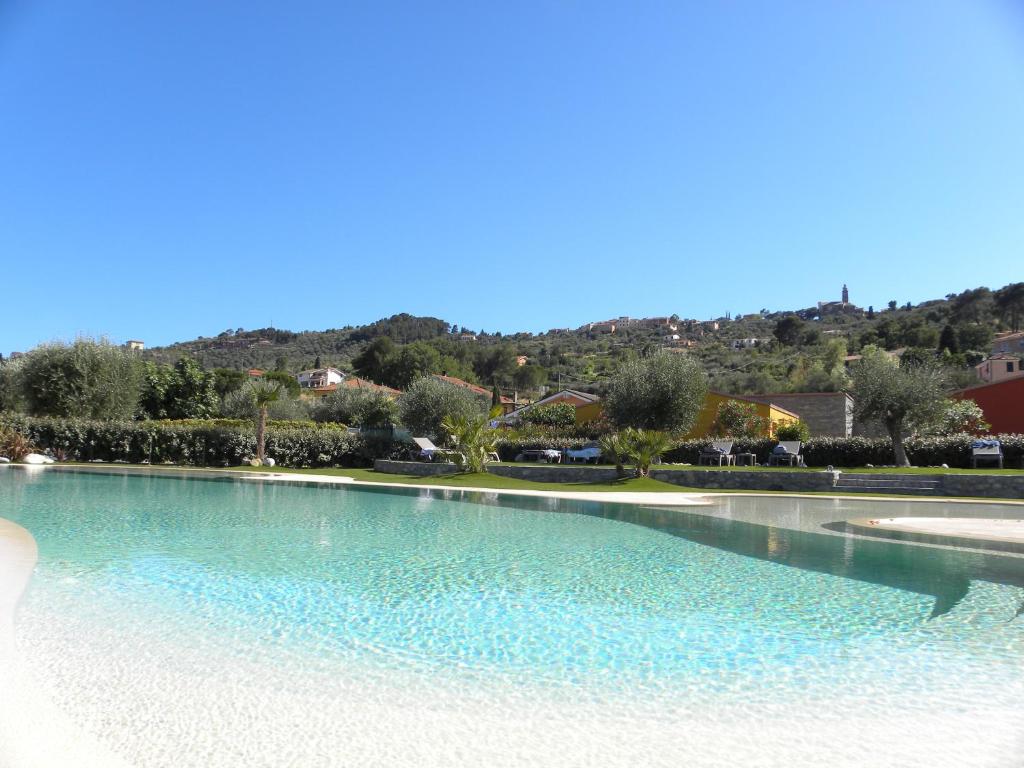 a large pool of water with a hill in the background at ReBi Village in Imperia