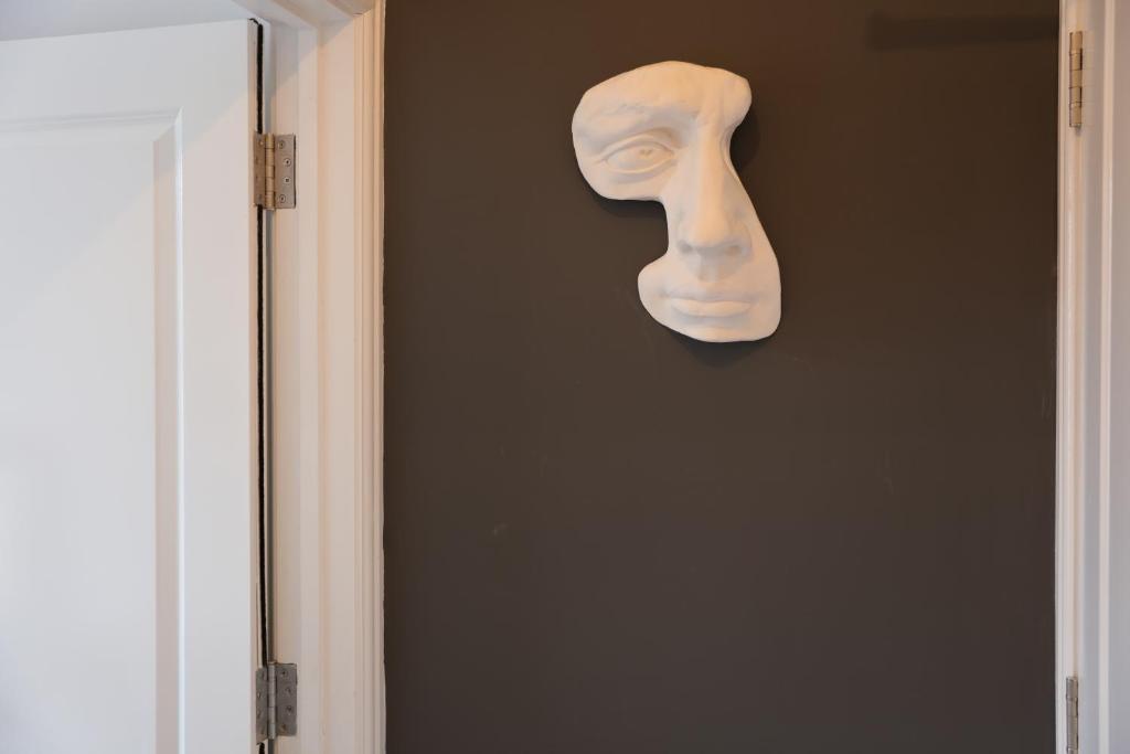 a mask hanging on a wall next to a door at Marleybone Victorian Apartment in London