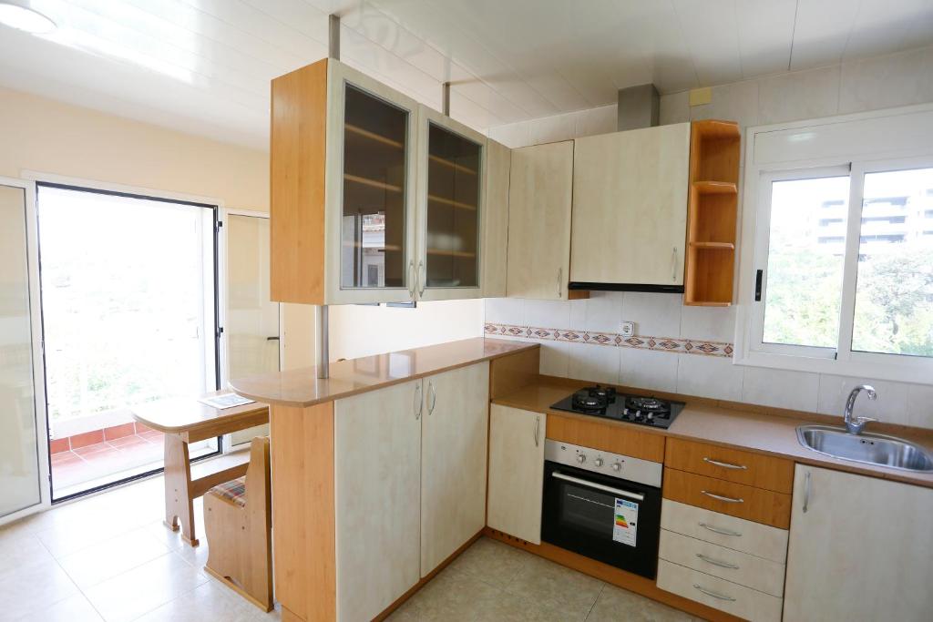a kitchen with wooden cabinets and a sink at Villa hortencia in Tarragona
