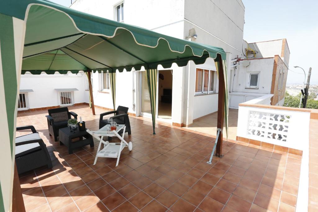 a patio with a green canopy on top of a building at Villa hortencia in Tarragona