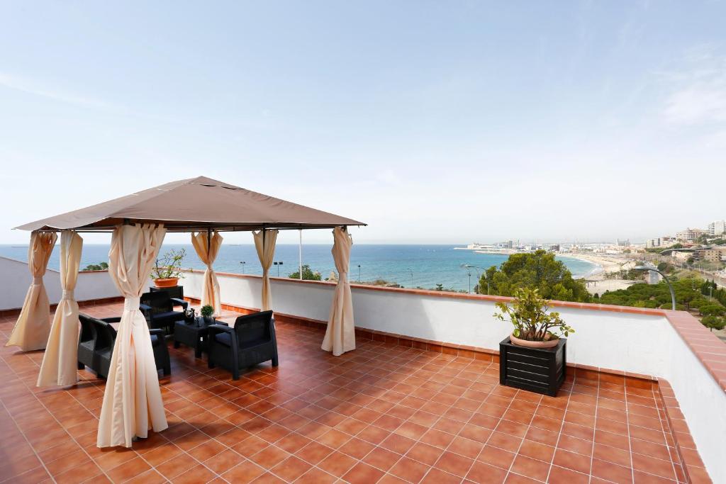 a balcony with a gazebo and the ocean at Villa hortencia in Tarragona