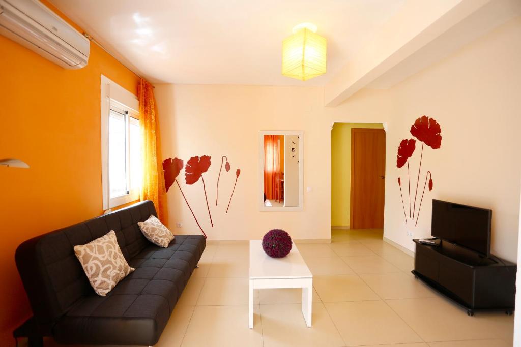 a living room with a couch and a tv at Villa hortencia in Tarragona