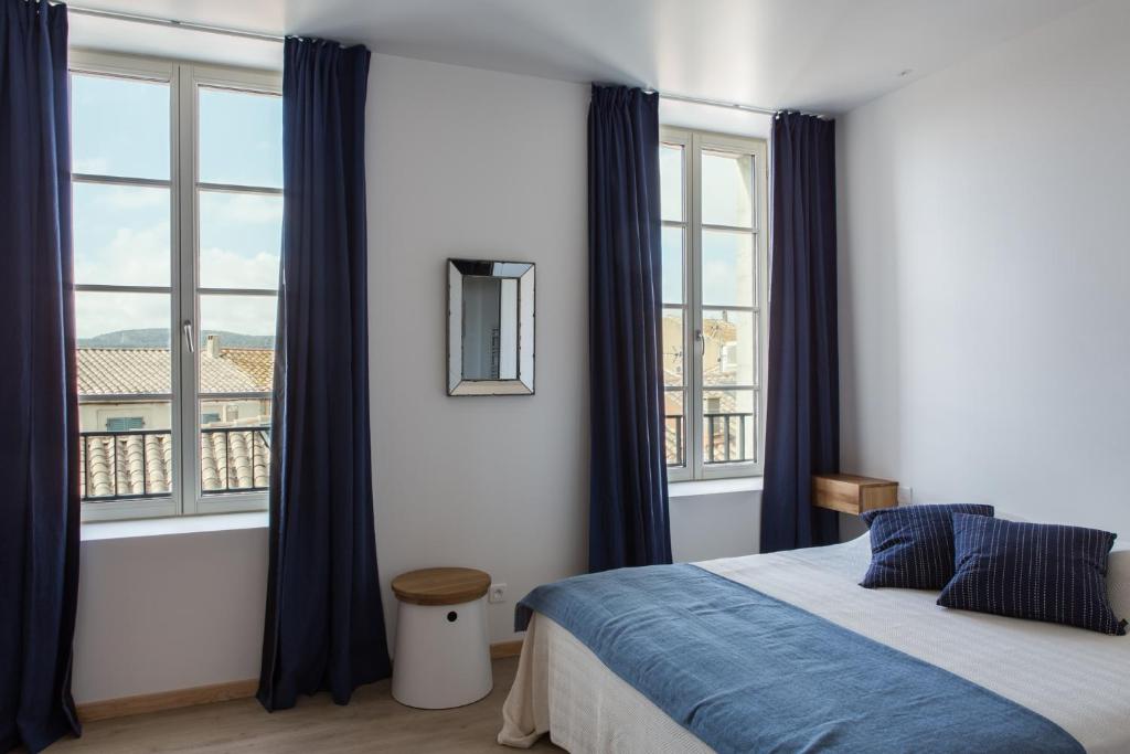een slaapkamer met een bed en een groot raam bij La Maison des Vendangeurs sur Mer in Gruissan