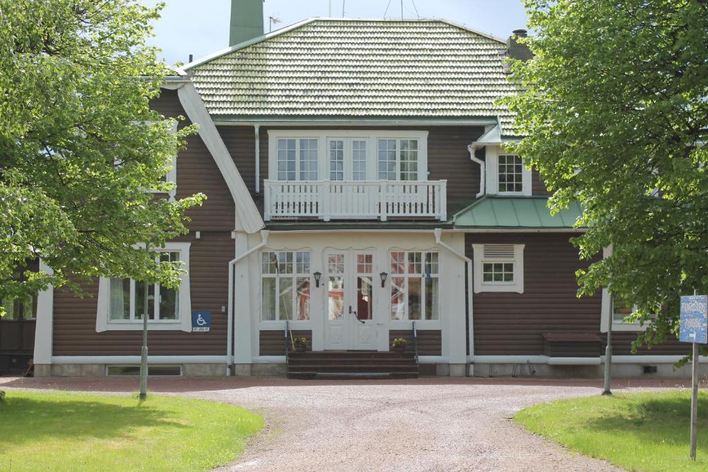 Casa marrón con puerta blanca y ventanas en Trunna Vandrarhem & Konferens, en Orsa