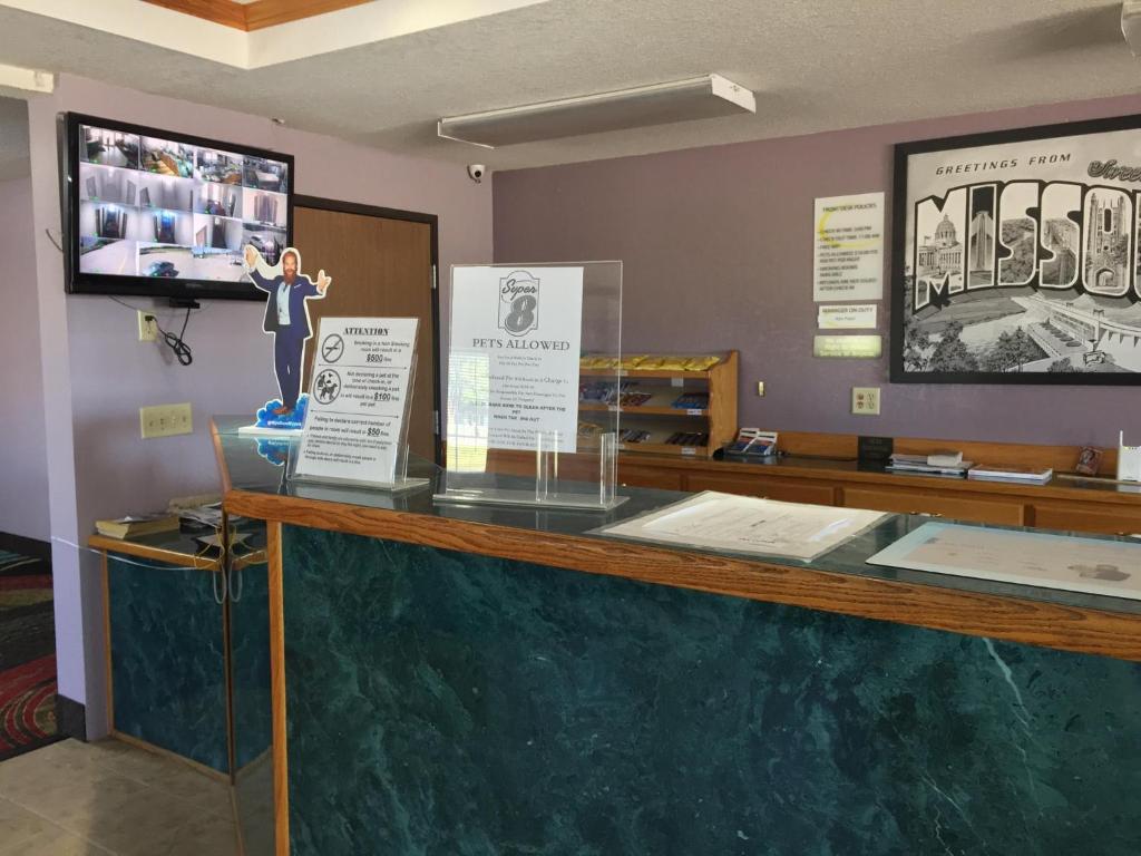a display case with a man on top of a counter at Super 8 by Wyndham Sweet Springs in Sweet Springs