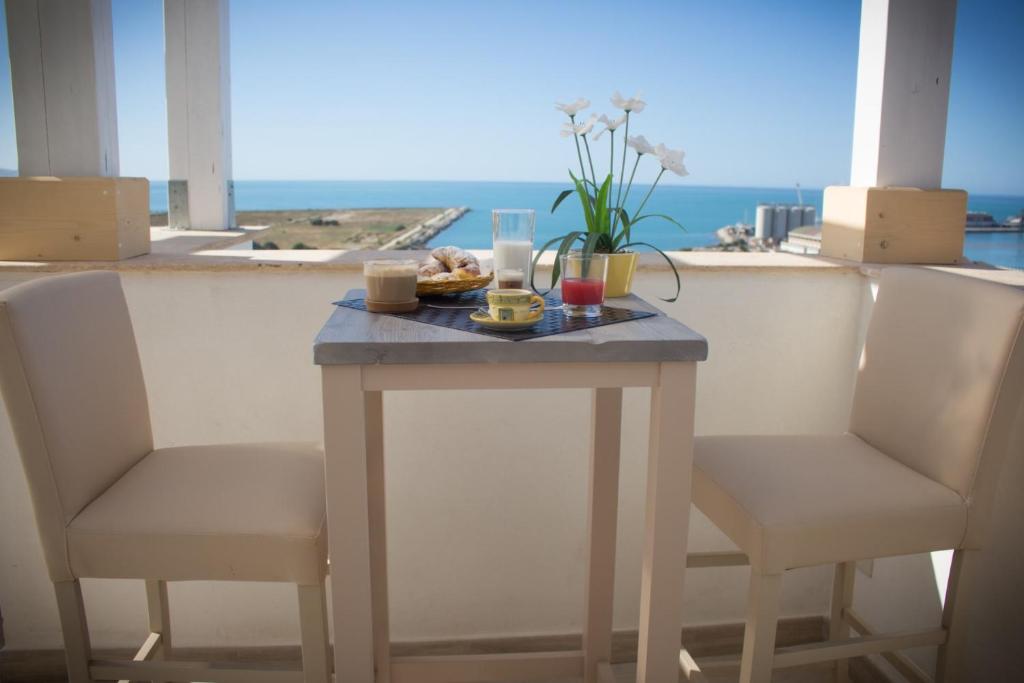 una mesa con dos sillas y una mesa con comida. en B&B Baglio Santa Croce, en Porto Empedocle
