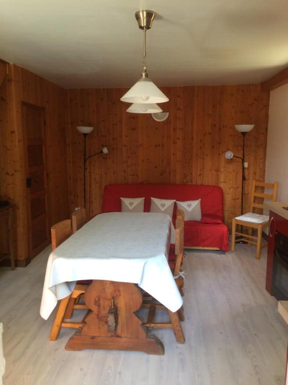 ein Wohnzimmer mit einem Tisch und einem roten Sofa in der Unterkunft Appartement Claude in Courchevel