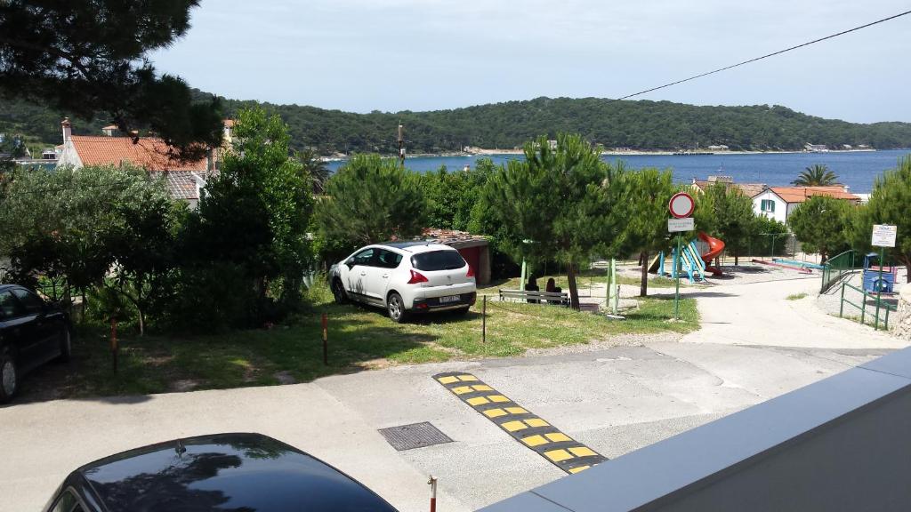 a white car parked in a parking lot near the water at Apartman Zoja in Mali Lošinj