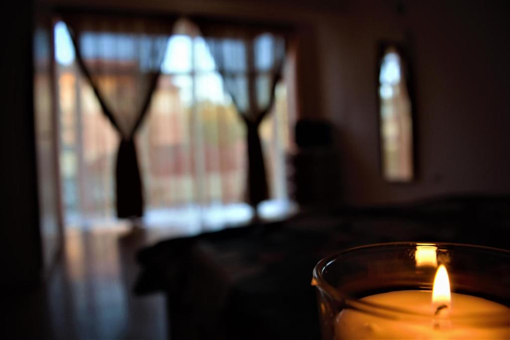 una candela seduta sopra un tavolo con una finestra di Casa Rendez Vous a Constanţa