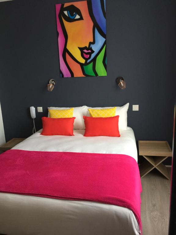 um quarto com uma cama grande e uma pintura na parede em Hotel Ar Terra Nova em Saint Malo