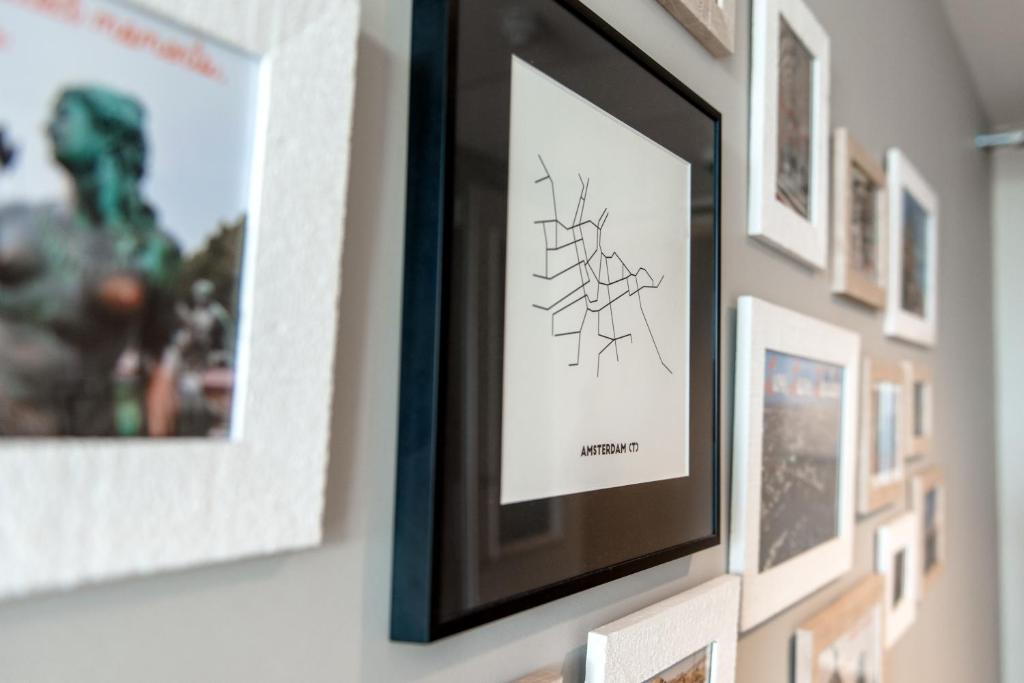 a picture frame hanging on a wall with pictures at Citiez Hotel Amsterdam in Amsterdam