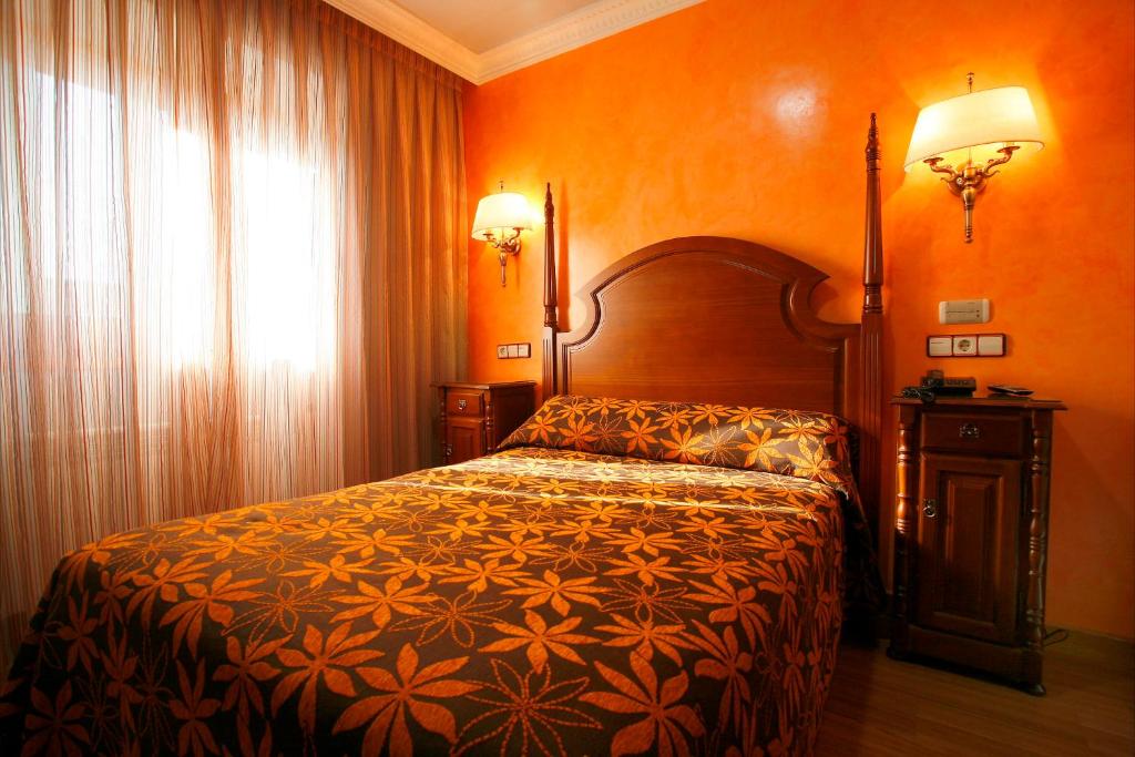 een slaapkamer met een bed in een kamer met oranje muren bij Hostal Victoria I in Madrid