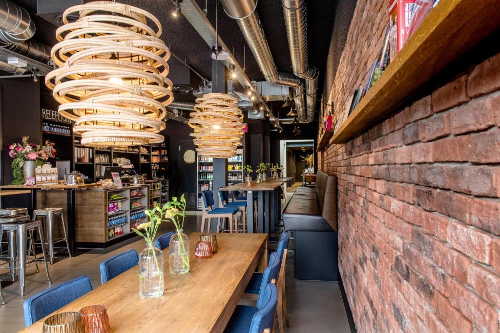 a brick wall in a restaurant with tables and chairs at Citiez Hotel Amsterdam in Amsterdam