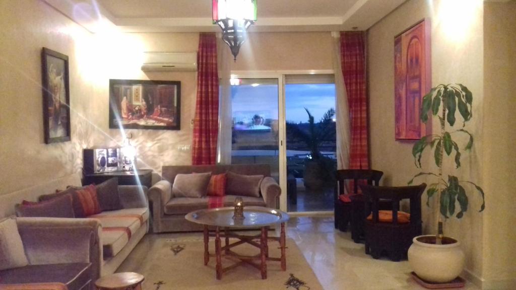 a living room with a couch and a table at Perle de Tamaris in Dar Bouazza