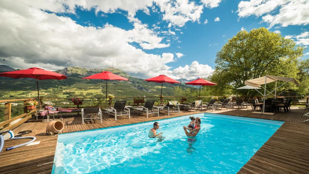 dos personas en una piscina en un complejo en Chalet les Moineaux Chambres d'Hôtes, en Jausiers