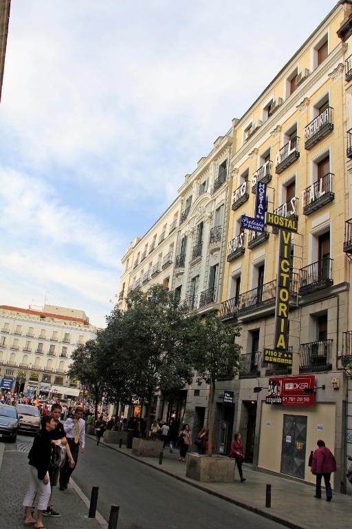 a building with a hotel sign on a city street at Hostal Victoria I in Madrid