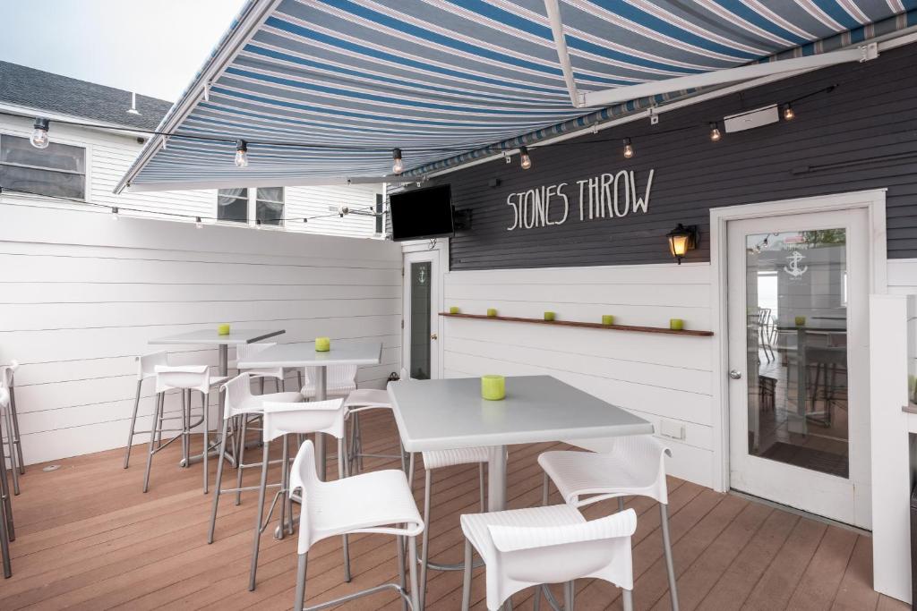 a restaurant with white tables and white chairs at Stones Throw in York Beach