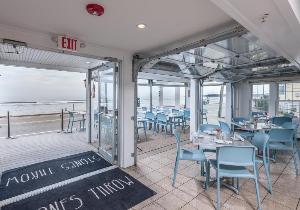 a restaurant with blue chairs and tables and the beach at Stones Throw in York Beach