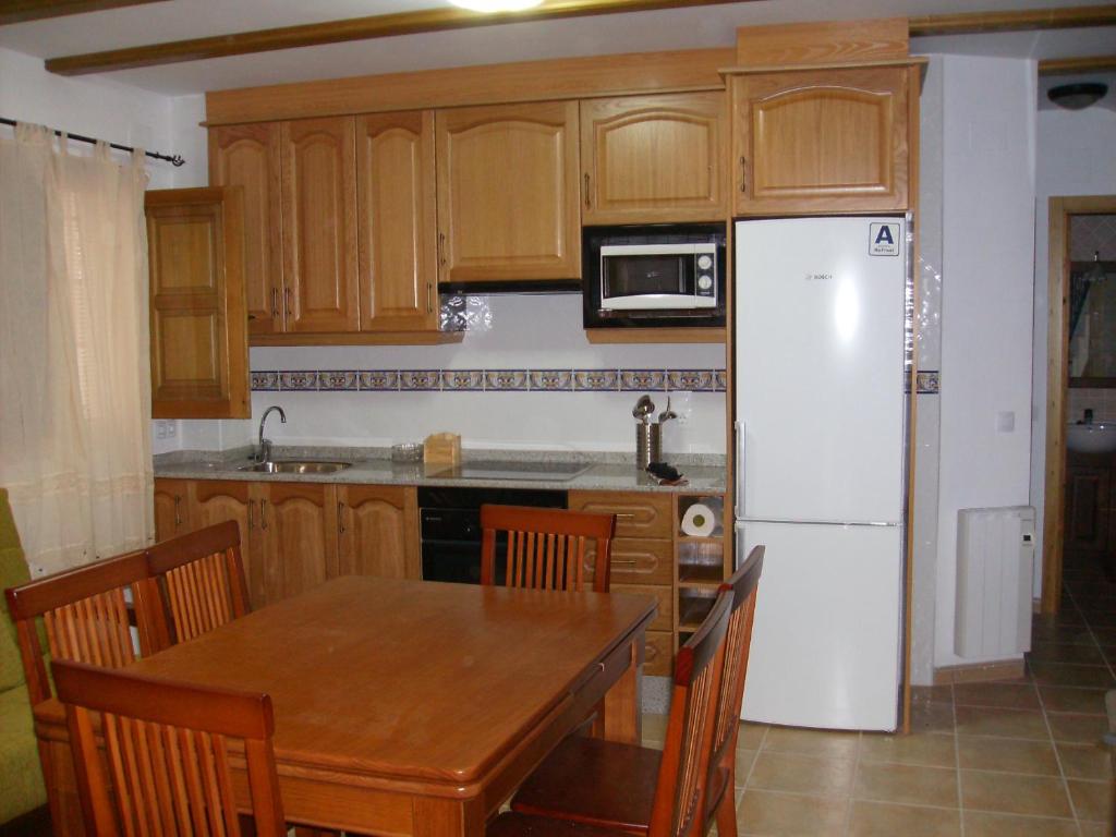 a kitchen with a table and a white refrigerator at Casa Arminda in Benafer