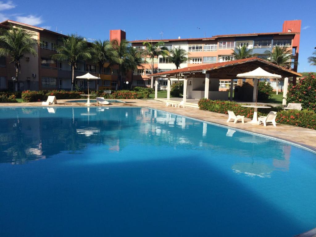 una gran piscina con sillas y un edificio en Apartamentos Praia do Futuro Prox Chico do Caranguejo, en Fortaleza