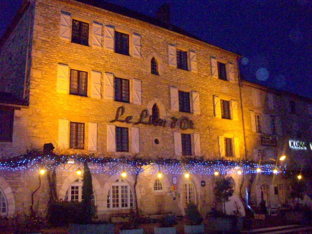 een groot gebouw met kerstverlichting ervoor bij Logis Hôtels - Hôtel et Restaurant Le Lion d'Or in Gramat