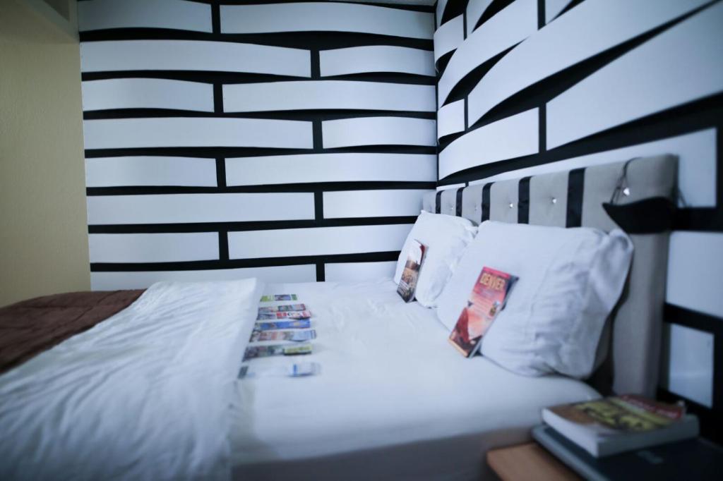 a bed with white sheets and pillows in a room at Airport Lay Over in Denver