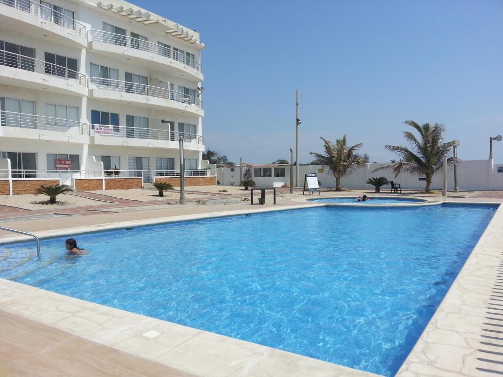 a large swimming pool in front of a building at Villa Altamar in Playas