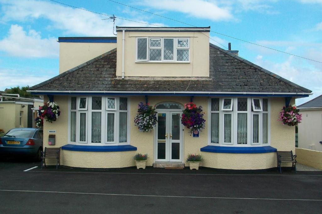 a yellow house with flowers on the windows at BlueHaven in Newquay