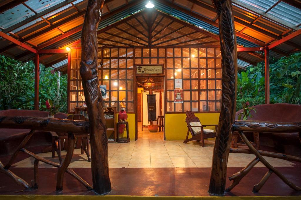 a room with a wooden building with chairs in it at Tierra de Sueños Lodge & Wellness Center in Puerto Viejo