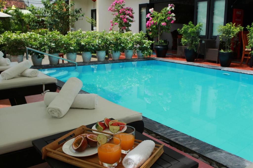 ein Tablett mit Essen auf einem Tisch neben dem Pool in der Unterkunft Phuc Thao Villa in Hoi An