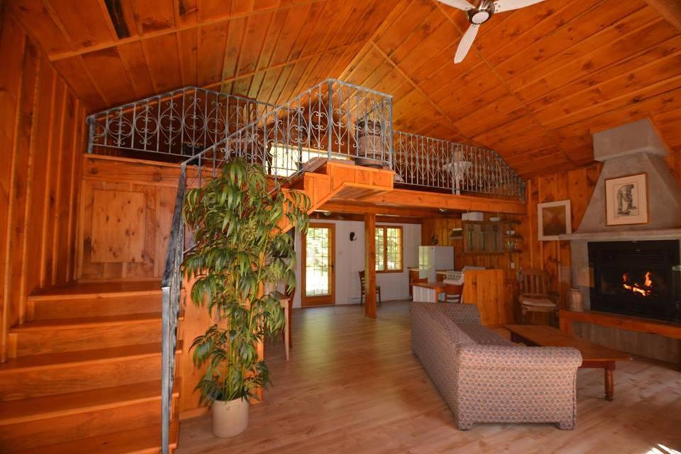 ein Wohnzimmer mit einer Treppe in einem Holzhaus in der Unterkunft La Sapinette in Val-David