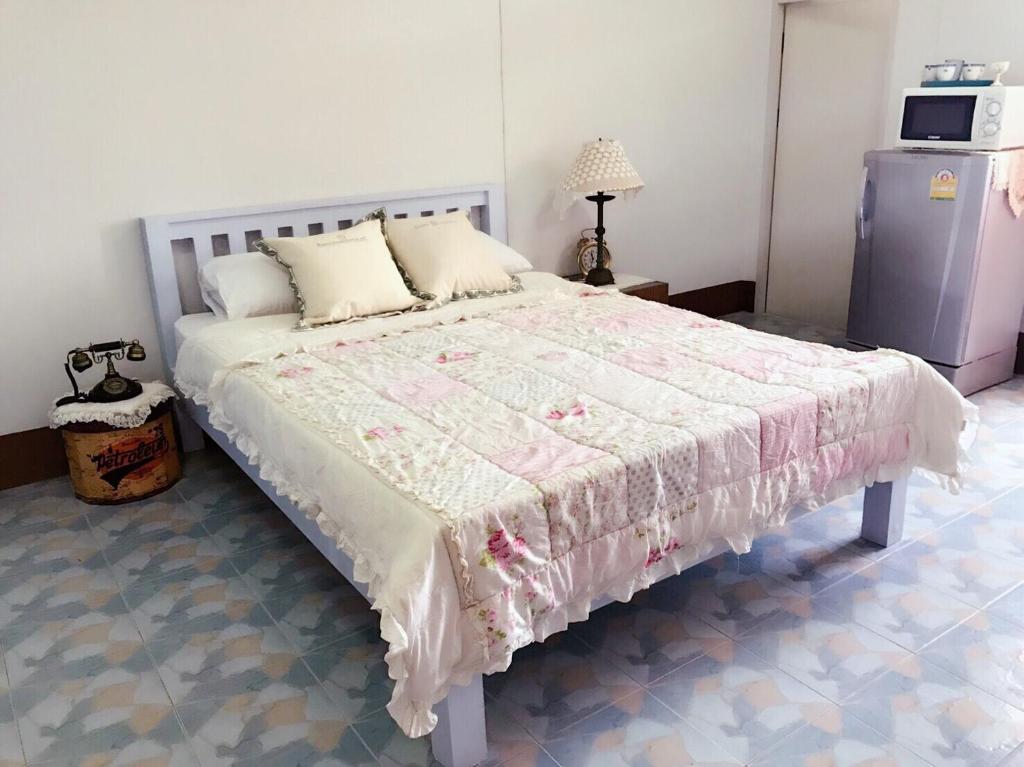 a bedroom with a bed with a pink and white blanket at Chanathinat Place in Udon Thani