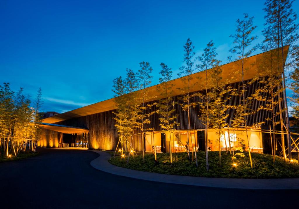 ein Gebäude in der Nacht mit Bäumen davor in der Unterkunft The Meibia Miyazaki in Miyazaki