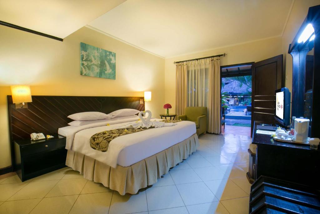 Postel nebo postele na pokoji v ubytování Legian Paradiso Hotel