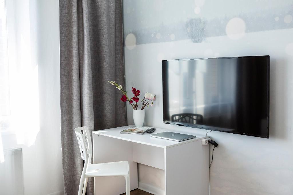 un escritorio blanco con TV en la pared en Apartments ODIN in city centre en Irkutsk